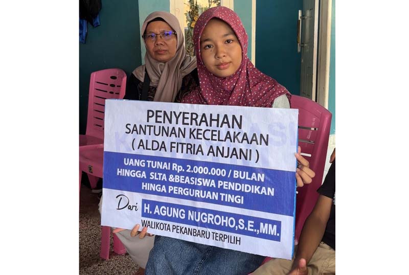Alda Fitria Anjani memperlihatkan bantuan yang diberikan secara simbolis oleh Wali Kota Pekanbaru terpilih Agung Nugroho di Pekanbaru, Ahad (5/1/2025).