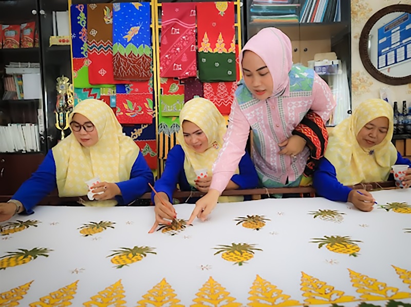 Dewi Asdinar, Ketua PKK Kecamatan Mandau saat melakukan produksi Batik Mandau yang merupakan ikon daerah, batik ini merupakan binaan PT Pertamina Hulu Rokan lewat program TJSL.