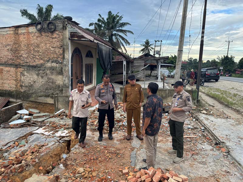 Kalaksa BPBD Pelalawan Zulfan SPi MSi (tengah) meninjau kondisi 7 KK di Desa Delik Kecamatan Pelalawan yang akan mengungsi setelah rumah mereka rusak dilanda longsor, Rabu (8/1/2025).