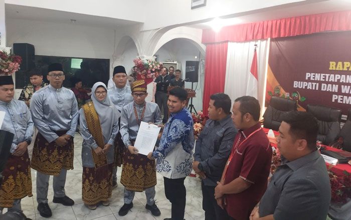 Ketua KPU Bengkalis Agung Kurniawan menyerahkan SK Penetapan Paslon Bupati dan Wakil Bupati terpilih 2024 kepada Wakil Ketua DPRD Bengkalis M Arsya Fadilah, Kamis (9/1/2025).