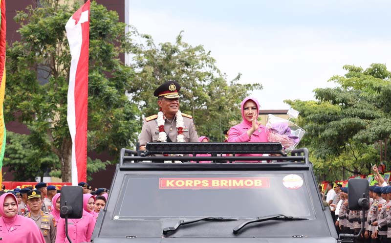 Pejabat lama Wakapolda Riau Brigjen Pol K Rahmadi beserta istri saat diarak menggunakan kendaraan taktis (rantis) saat pelepasan di Mapolda Riau, Kamis (9/1/2025).