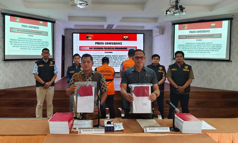 Wakasat Reskrim Polresta Pekanbaru AKP Markus Sinaga (kiri ) bersama Kanit Tipikor Polresta Pekanbaru Iptu Isnaini (kanan) menunjukkan dokumen barang bukti dan tersangka tindak pidana dugaan korupsi