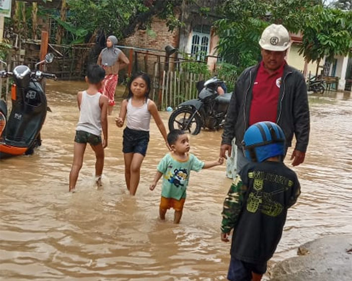 Anak-anak di Desa Kuntu, Kecamatan Kamparkiri, Kabupaten Kampar, bermain air dari luapan Sungai Subayang, Senin (13/1/2025).