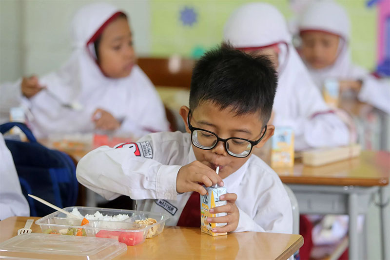 Murid SD Taquma Surabaya saat menikmati menu Makan Bergizi Gratis.