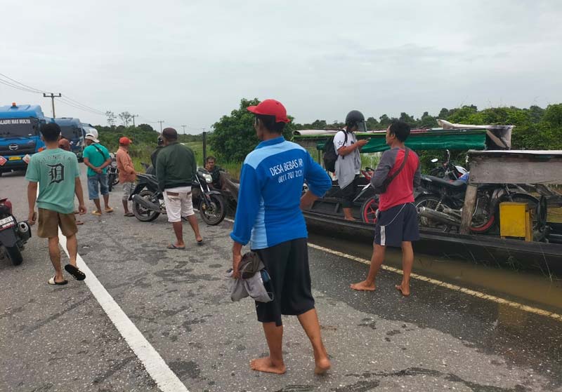 Sejumlah masyarakat Pangkalankerinci yang akan menuju Langgam menaikkan kendaraan saat memanfaatkan penyeberangan menggunakan pompong di Jalan Pemda Koridor RAPP, Pangkalankerinci, Pelalawan.