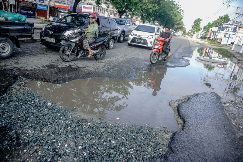 Pengendara menghindari lubang dan genangi air di Jalan Soekarno-Hatta ujung, simpang Jalan Kaharuddin Nasution, beberapa hari lalu.