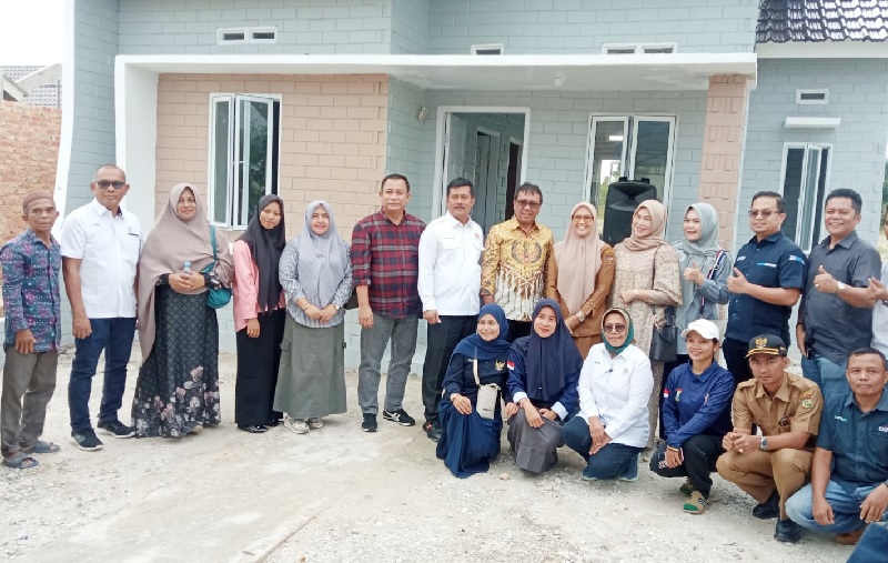 Direktur Operasional PT Semen Padang Pri Gustari Akbar (6 kiri) dan Ketua DPD REI Riau Elvi Supryadi (7 kiri) foto bersama dengan penerima bantuan rumah untuk keluarga miskindi Desa Karya Indah.
