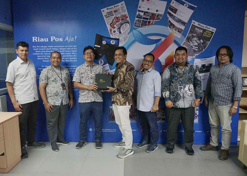 Pemimpin Wilayah PT Pegadaian Kanwil Pekanbaru Eko Supriyanto dan jajaran menyerahkan cendera mata kepada Direktur Utama Riau Pos Ahmad Dardiri dan jajaran saat kunjungan ke Kantor Riau Pos