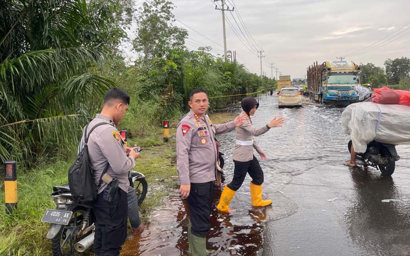 Kapolres Pelalawan, AKBP Afrizal Asri SIK didampingi Kasatlantas Polres Pelalawan AKP Enggarani Laufria&nbsp;meninjau lokasi banjir Jalan Lintas Timur Km 83 Desa Kemang, Kecamatan Pangkalan Kuras