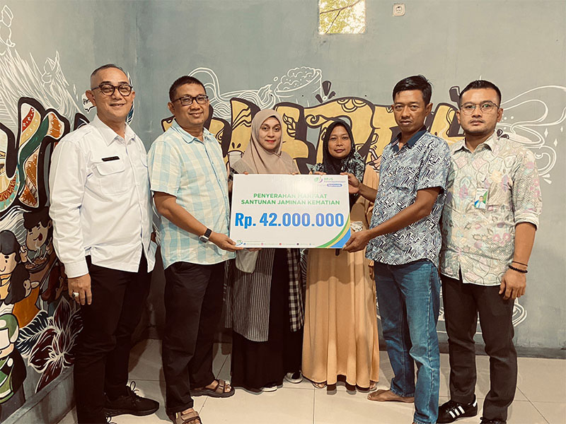 Kepala BPJS Ketenagakerjaan Cabang Pekanbaru Kota, Iman S Achwan mendampingi Owner Wareh Kupie Rijal Afrizal menyerahkan santunan JKM BPJS TK kepada ahli waris Farid Nur Zahran di Wareh Kupie