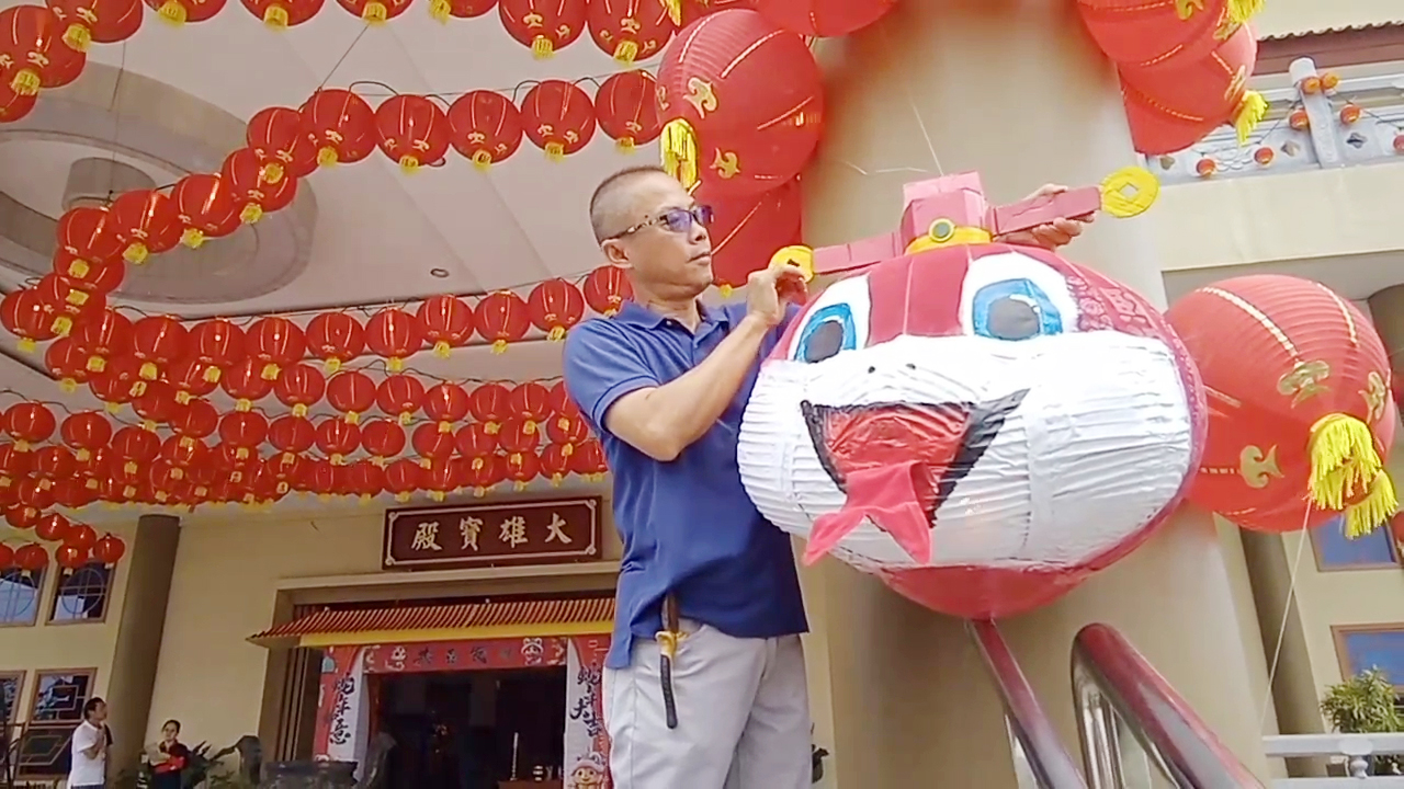 Pengurus memasang lampion bercorak ular kayu di salah satu tiang Maha Vihara Pusdiklat Bumi Suci Maitreya untuk menyambut Tahun Baru Imlek, Jumat (24/1/2025).