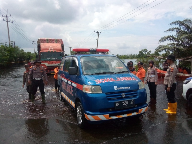 Petugas gabungan melakukan pengaturan arus lalu lintas di Jalintim Km 83 Desa Kemang yang masih direndam banir melalui sitem buka tutup jalan, Sabtu (25/1/2025) siang.