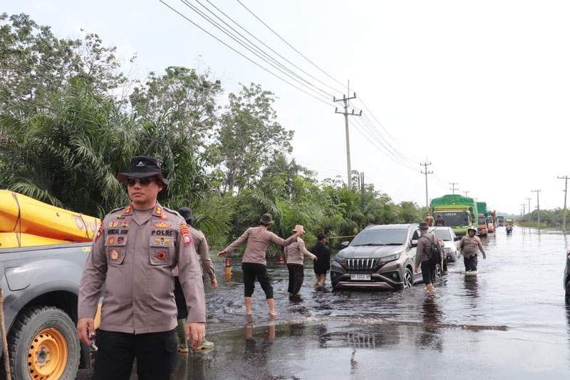 Personel Polres Pelalawan melakukan pengaturan arus lalu lintas di Jalan Lintas Timur Km 83 Desa Kemang, Kecamatan Pangkalan Kuras, Kabupaten Pelalawan,