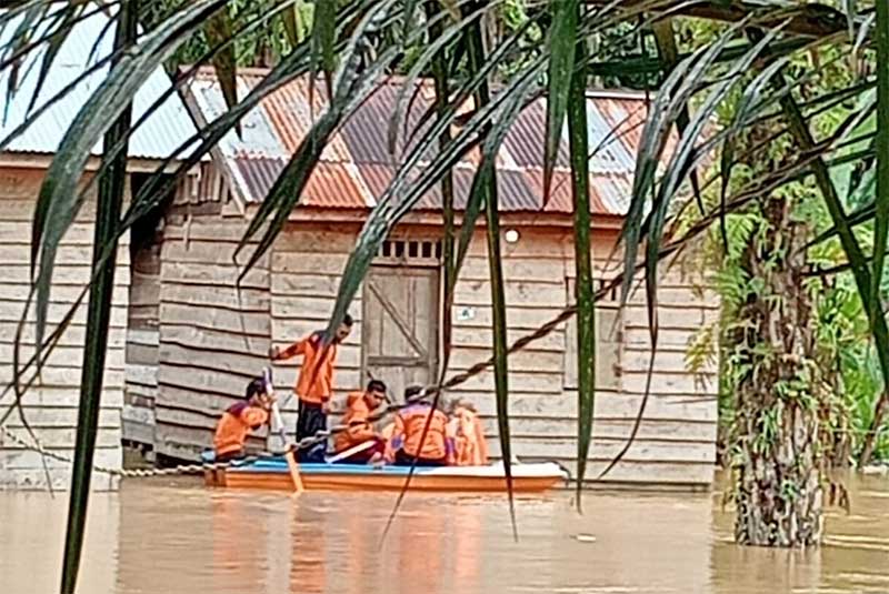 Anggota KPBD Inhu saat menyusuri rumah warga terendam akibat luapan air Sungai Cenaku, Selasa (28/1/2025).