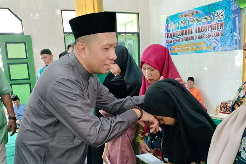 Ketua IKKKM Bengkalis menyerahkan santunan kepada anak yatim pada acara Isra Mikraj Nabi Muhammad SAW di Masjid Mujahidin Dusun Kampung Jawa Desa Bandul Kecamatan Tasik Putri Puyu, Kepulaauan Meranti,
