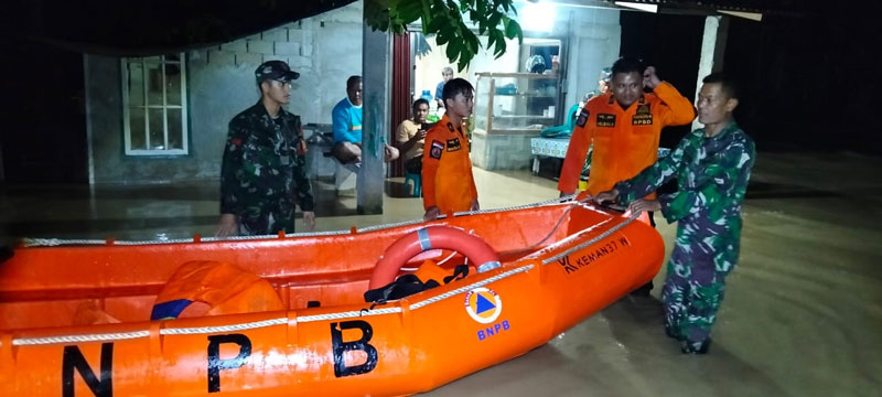 Petugas gabungan mengevakuasi warga Desa Petapahan, Kecamatan Gunung Toar, Kabupaten Kuantan Singingi yang  dilanda banjir, Senin (27/1/2025) malam.