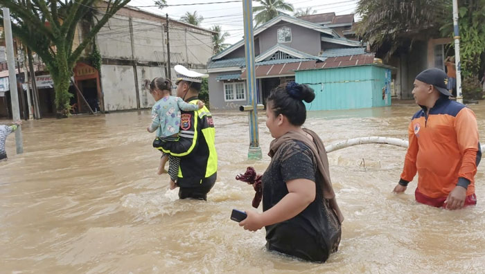 Personel Satlantas Polres Rohul bersama BPBD Rohul membantu evakuasi seorang anak saat banjir di Desa Babussalam, Kecamatan Rambah, Rabu (29/1/2025).
