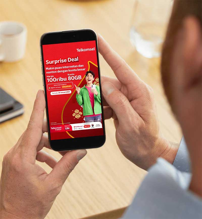 Salah seorang pelanggan Telkomsel membaca brosur promo paket super deal Imlek dari aplikasi.