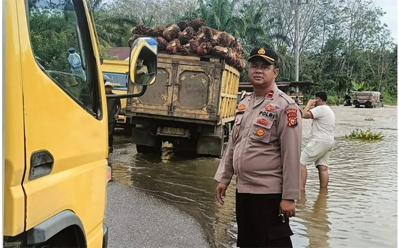 Kapolsek Rambah Hilir Ipda Jonnes SH turun kelapangan mengatur arus lalu lintas ruas jalan provinsi Simpang Kumu-Kota Tengah, Kamis (30/1/2025).