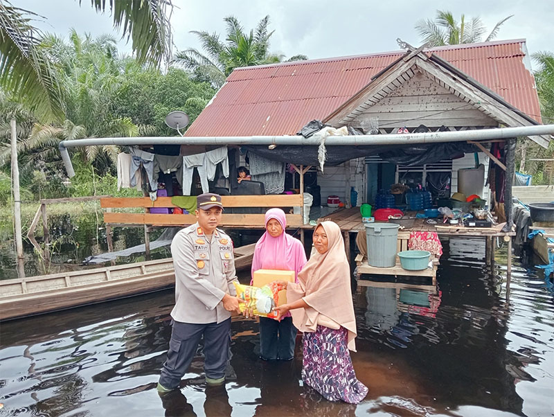 Kapolsek Pangkalan Kerinci AKP Tatit Rizkyan Hanafi STK SIK menyerahkan bantuan kepada warga terdampak di Perum Sosial Dusun Sungai Pabadaran Desa Rantau Baru, Kamis (30/1/2025) siang.