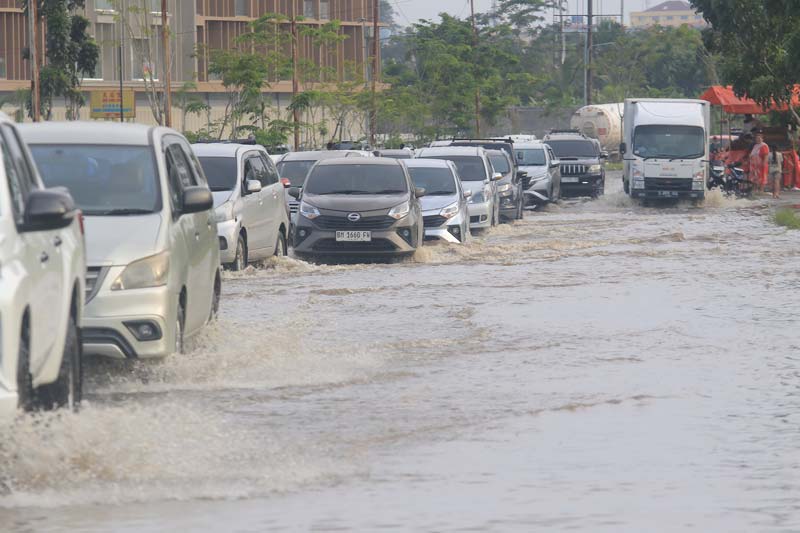 Kendaraan bermotor melewati genangan air di ruas Jalan Jenderal Sudirman ujung, Pekanbaru, Rabu (29/1/2025).