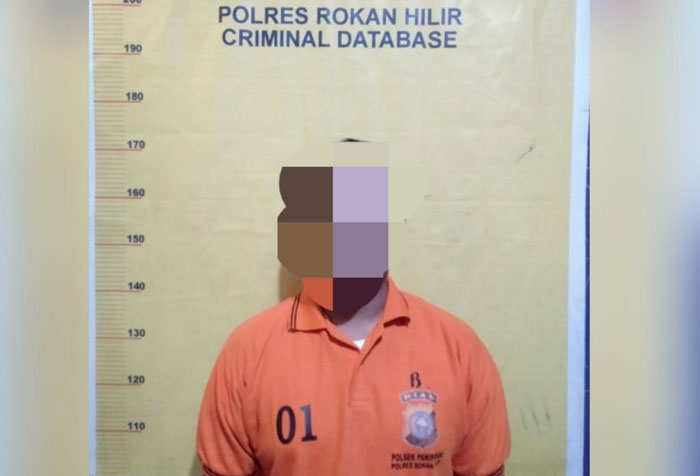 Tersangka Us Trg saat diamankan di Mapolsek Panipahan.