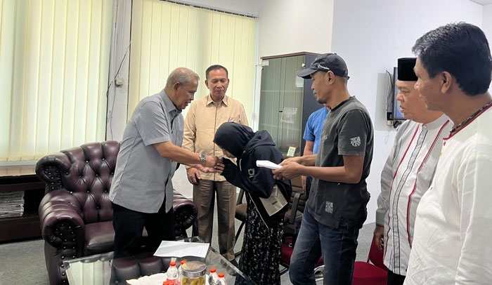 Ketua umum KONI Riau Iskandar Hoesin (kiri) serahkan santunan kepada keluarga Almarhumah Halimahtu Sadiah, Jumat (31/1/2025) di KONI Riau, Jalan Gajah Mada Pekanbaru.