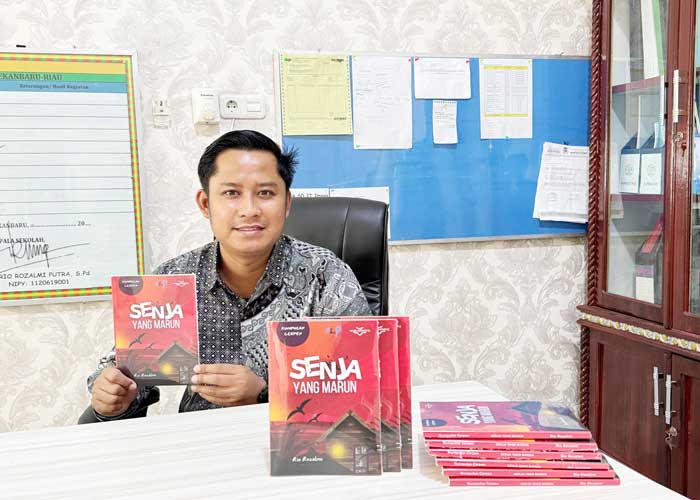 Rio Rozalmi foto bersama buku kumpulan cerpen pertamanya, Senja yang Marun, di Pekanbaru, Jumat (31/1/2025).