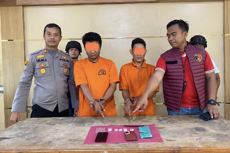 Kapolsek Kepenuhan AKP Ulik Iwanto SH menunjukkan dua wajah tersangka inisial VA dan HE beserta barang bukti saat diamankan di Mapolsek Kepenuhan, Ahad (2/2/2025).