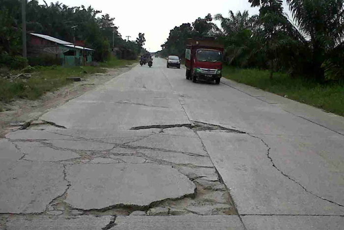 Para pengemudi kendaraan bermotor melintasi Jalan Lintas Timur KM 78 yang mengalami kerusakan dampak banjir yang telah mulai surut total, Rabu (5/2/2025).
