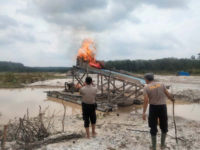 Personel Polsek Kuantan Tengah membakar rakit PETI di Desa Titian Modang Kopah, Kecamatan Kuantan Tengah yang sudah ditinggal pergi pekerja