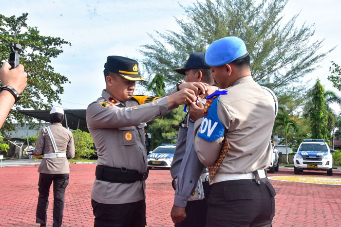 Wakapolres Kompol Anto Rama Putra memasang pita kepada petugas Satlantas  untuk Operasi Keselamatan Lancang Kuning Cipta Kondisi.