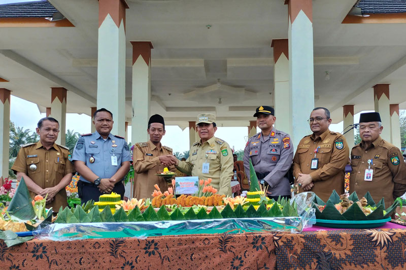 Bupati Rohul H Sukiman menyerahkan potongan nasi tumpeng dalam acara syukuran atas selesainya pembangunan Danau Gunung Sari Desa Pasir Intan, Kecamatan Bangun  Purba.