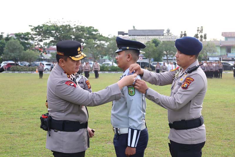 Kapolda Riau Irjen Pol Mohammad Iqbal (kiri) menyematkan pita kepada personel Operasi Keselamatan Lancang Kuning 2025 di Polda Riau, Senin (10/2/2025).