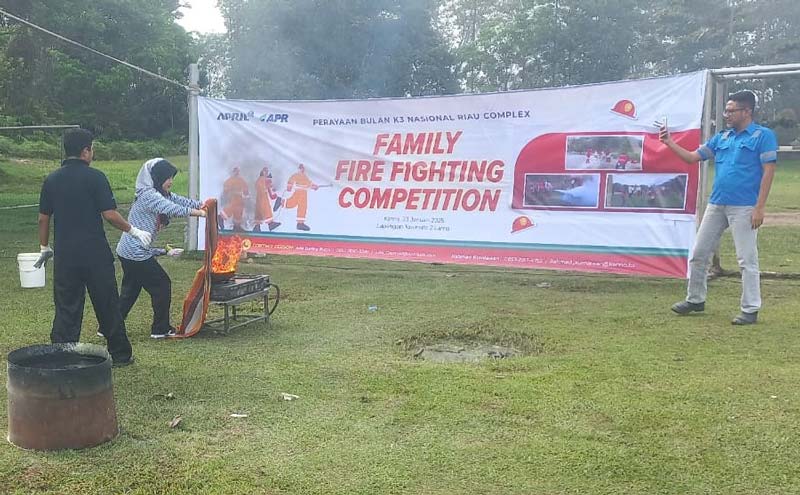 Seorang karyawan di perusahaan melakukan simulasi pemadaman api dalam memeriahkan Peringatan Bulan Keselamatan dan Kesehatan Kerja Nasional 2025