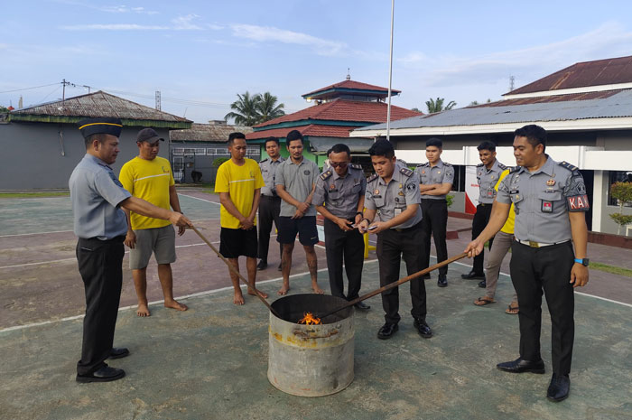 Kepala Rutan Rengat, Ridar Firdaus Ginting AMd IP SH bersama pejabat struktural musnahkan hasil razia kamar hunian.
