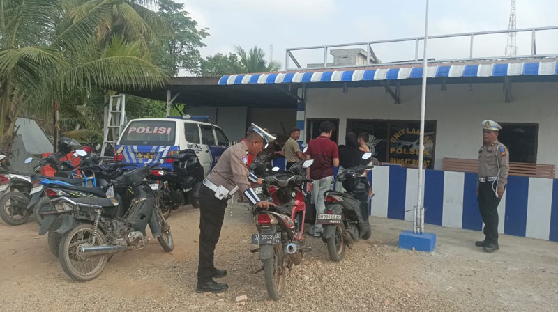 Personel Polsek Rengat Barat membawa sepeda motor warga saat terjaring dalam Operasi Keselamatan Lancang Kuning 2025, Kamis (13/2/2025).