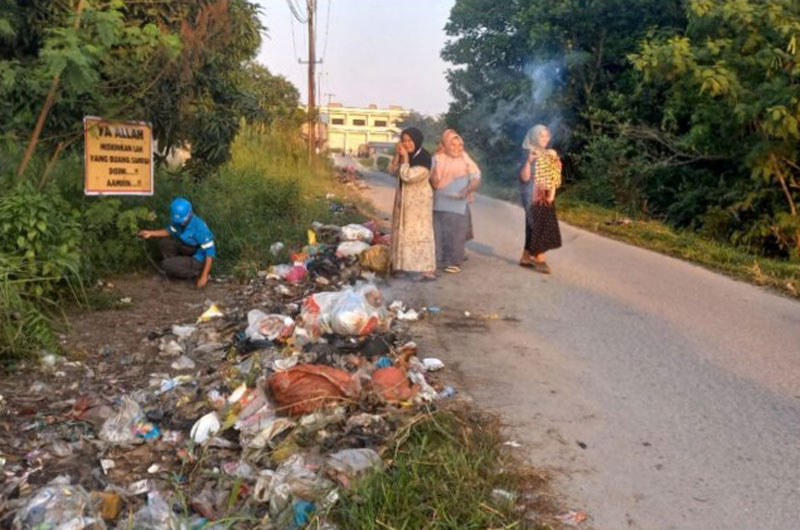 Emak-emak gotong-royong membersihkan sampah dengan cara dibakar di Jalan Wajib Senyum, Pangkalankerinci, Kamis (13/2/2025).