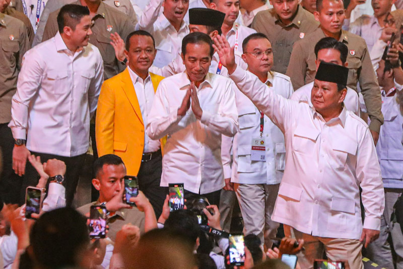 Presiden RI yang juga Ketua Umum Partai Gerindra, Prabowo Subianto berjalan didampingi Presiden ke-7 Joko Widodo dan beberapa  politisi sambil melambaikan tangan kepada massa.