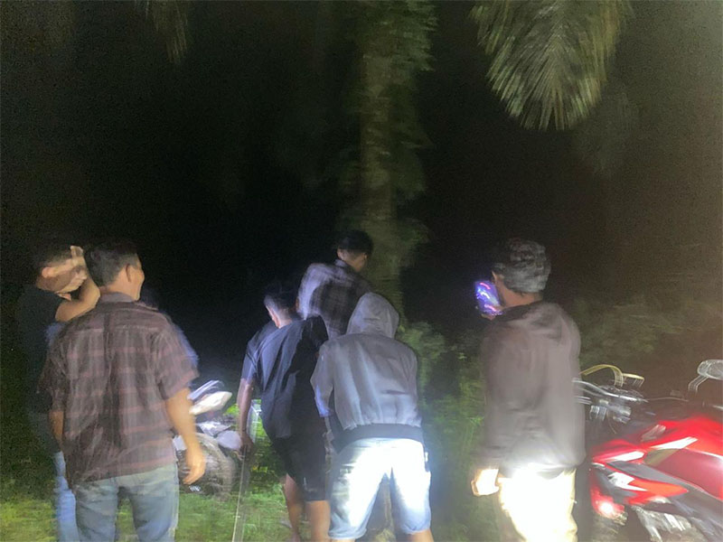 Personel Satlantas Polres Siak beserta warga mencari pengendara motor yang sesat di tengah kebun sawiit