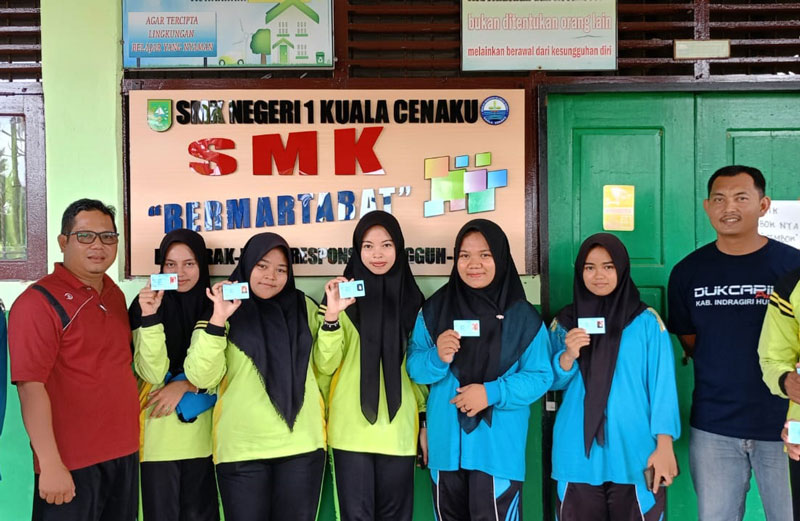 Tim Disdukcapil Kabupaten Inhu foto bersama dengan perwakilan siswa SMKN 1 Kuala Cenaku saat penyerahan KTP-el, baru-baru ini.