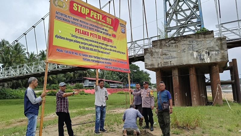 Polsek Kuantan Tengah bersama aparat desa dan masyarakat melakukan pemasangan spanduk larangan aktivitas PETI di Desa Seberang Taluk Kecamatan Kuantan Tengah, Sabtu (22/2/2025).