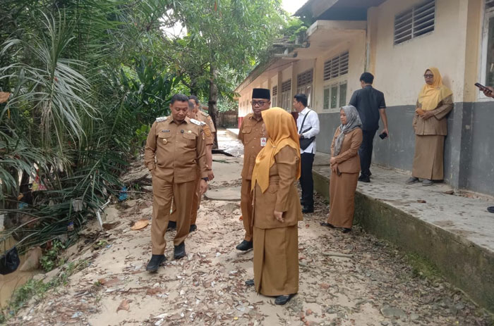 Wakil Wali Kota Pekanbaru Markarius Anwar didampingi Kepala SMPN 31 Pekanbaru Jannatul Soleha meninjau halaman belakang sekolah yang sempat dilanda banjir, Senin (24/2/2025).