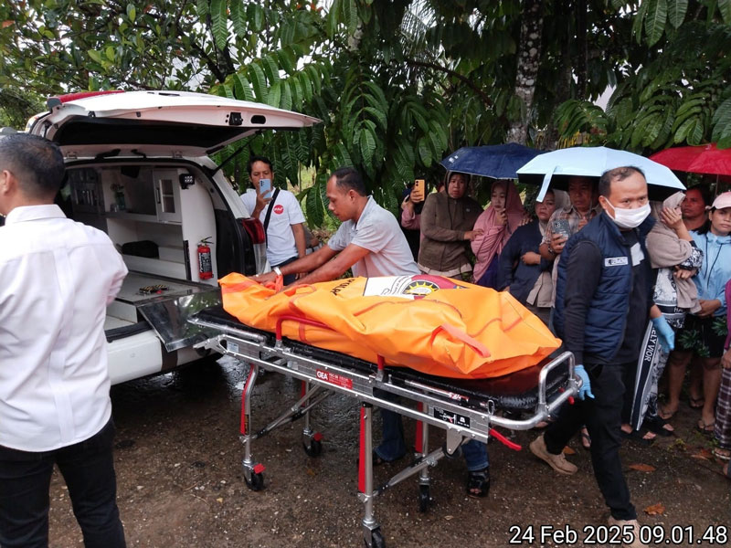Petugas kepolisian saat mengevakuasi jenazah Juniwarti untuk dibawa ke RSUD Telukkuantan, Senin (24/2/2025).