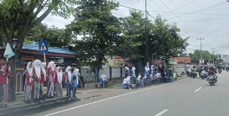 Sejumlah pelajar tingkat SMP dalam Kota Rengat saat pulang sekolah menunggu jemputan, Selasa (25/2/2025).