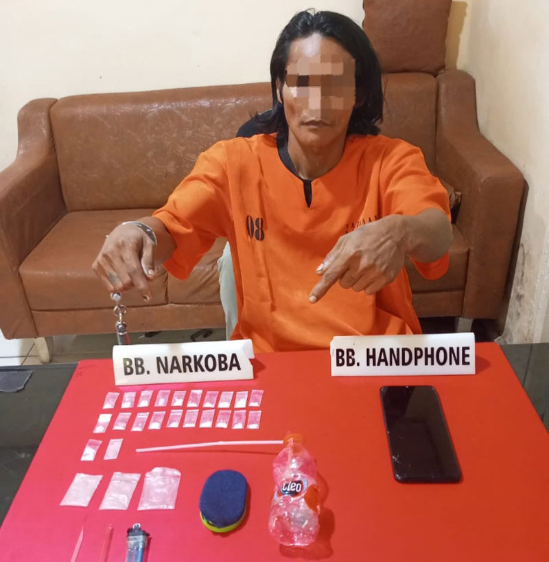Tersangka pengedar narkoba jenis sabu berinisial AD (39) menunjuk barang bukti sabu saat diamankan di Polres Kampar, Ahad (23/2/2025).&nbsp;