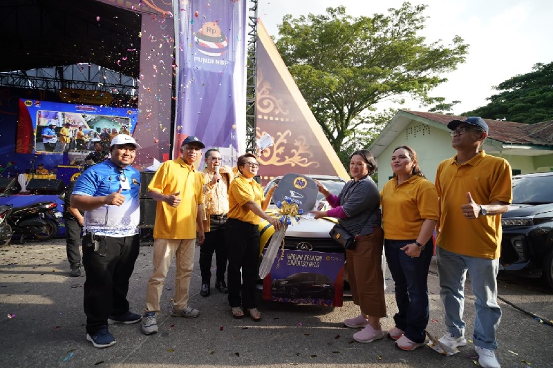Dirut PT NBP, Hendi Apriliyanto menyerahkan kunci secara simbolis kepada nasabah pemenang mobil Toyota Avanza,  di Lapangan Koramil 03 Mandau, Duri, pekan lalu.