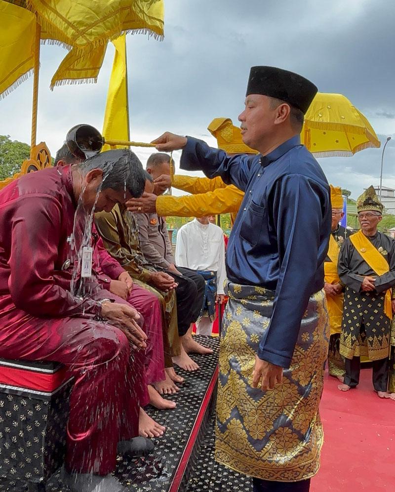Wakil Bupati Pelalawan H Husni Tamrin SH melakukan penyiraman air kepada Camat Pelalawan Yusman Effendi dalam prosesi adat mandi Balimau Sultan di pinggir Sungai Kampar