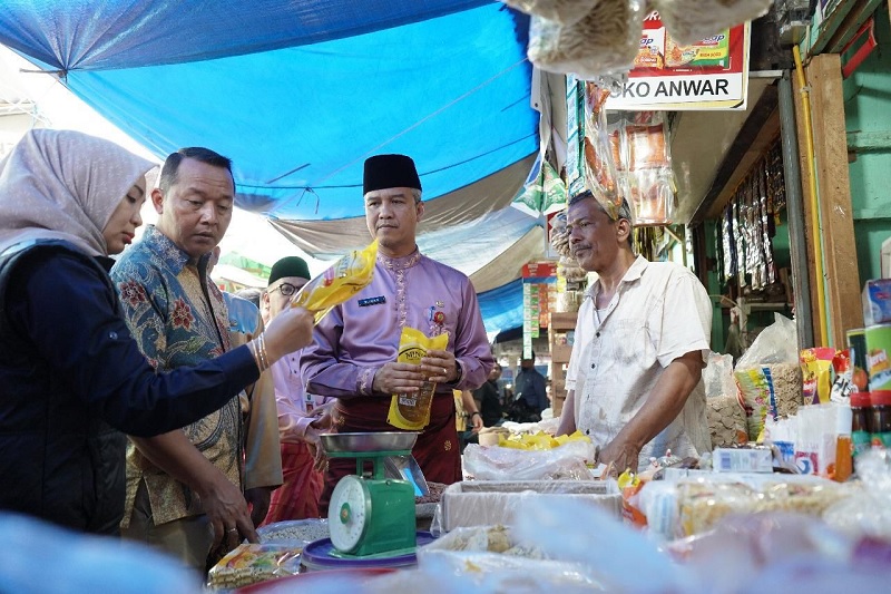 Dirkrimsus Polda Riau Kombes Pol Ade Kuncoro (nengenakan batik) saat mengecek harga kebutuhan pokok di pasar tradisional di Pekanbaru, Jumat (28/2/2025).