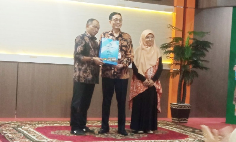 Kepala Balai Bahasa Provinsi Riau, Toha Machsum (tengah), saat menerima cendera mata dari Kepala Subbagian Umum Endry Satya Ramadhan, dalam sebuah acara di Pekanbaru, Jumat (28/2/2025).